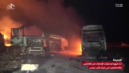 Sur une capture d'écran de la chaîne yéménite pro-houthis al-Masirah, des camions détruits par les flammes sont visibles dans le port de Ras Isa (côte ouest du Yémen), le 18 avril 2025. (AL-MASIRAH TV / AFP)